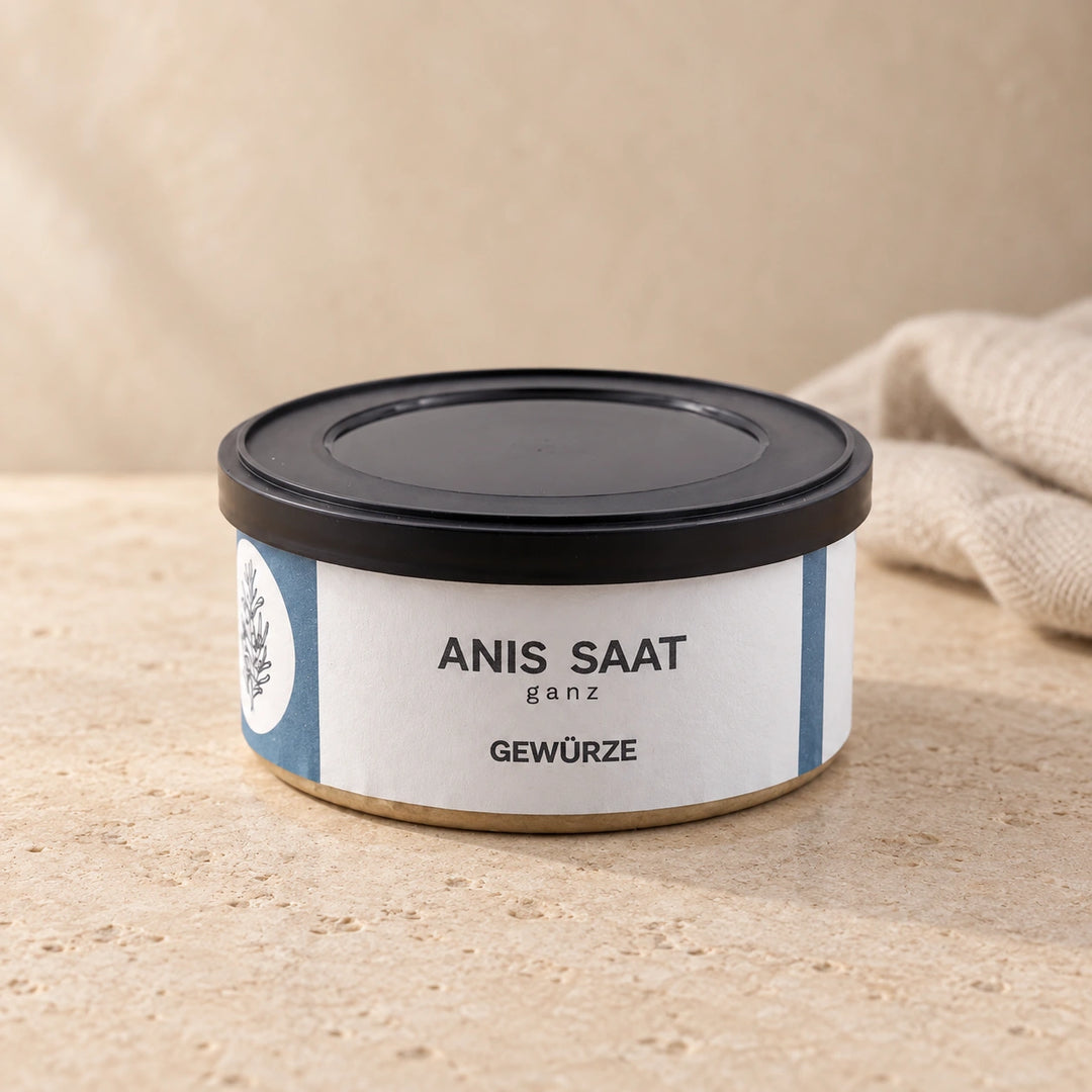 Anis-Saat ganz von Jungermann Gourmet in der flachen Gewürzdose mit schwarzem Deckel auf hellem Naturstein.
