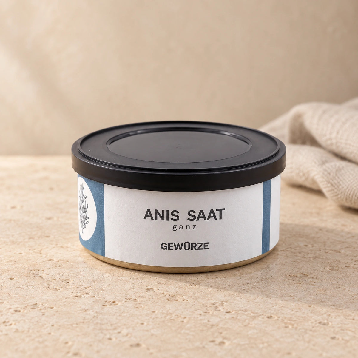 Anis-Saat ganz von Jungermann Gourmet in der flachen Gewürzdose mit schwarzem Deckel auf hellem Naturstein.