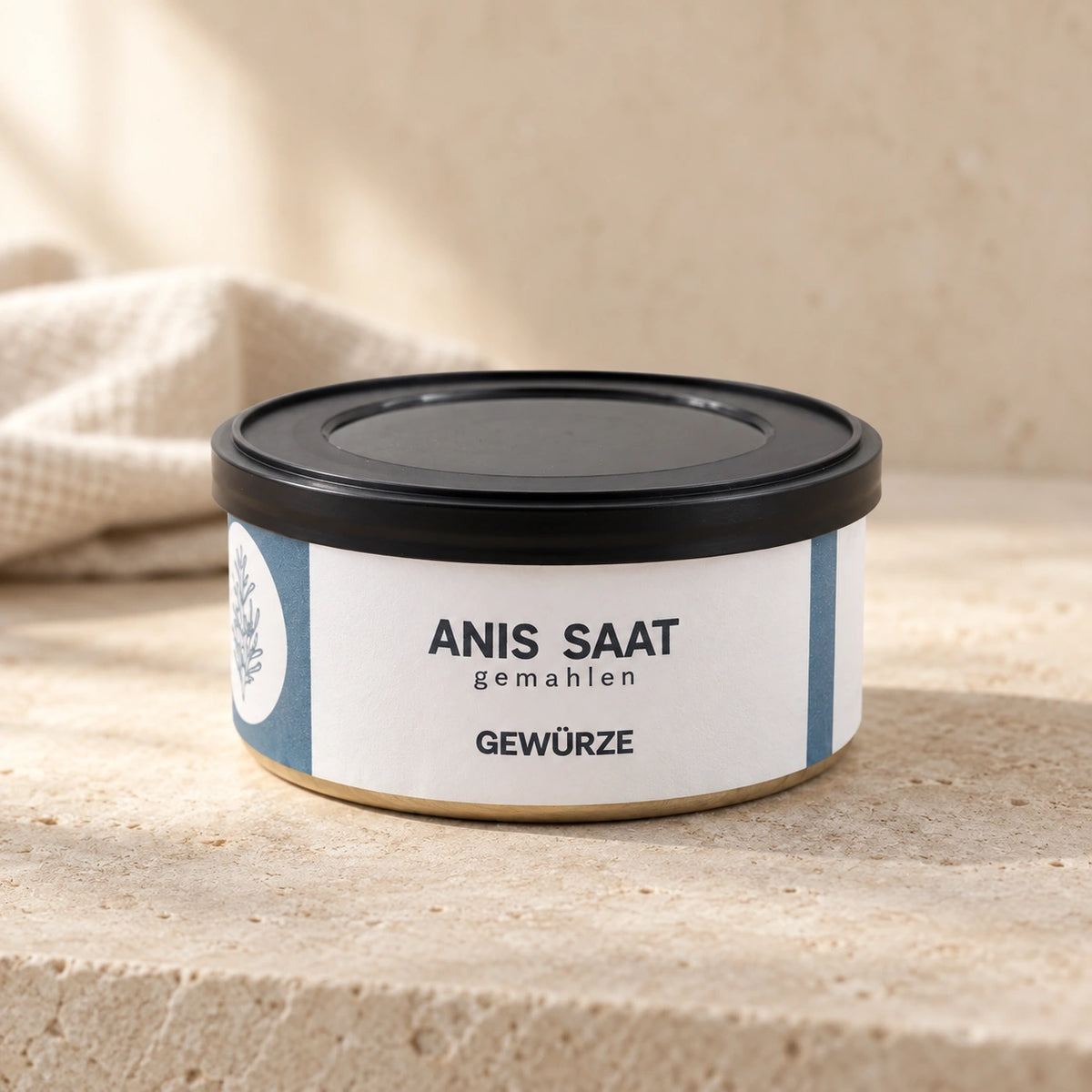 Anis-Saat gemahlen von Jungermann Gourmet in der flachen Gewürzdose mit schwarzem Deckel auf hellem Naturstein.