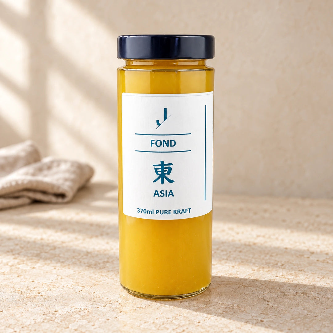 Asia-Fond von Jungermann Gourmet im hohen Glas mit dunklem Deckel und weißem Etikett auf hellem Naturstein.