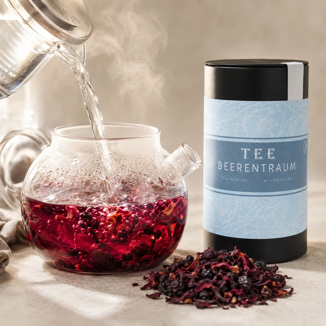 Beerentraum Früchte Tee wird mit heißem Wasser in einer Glasteekanne aufgegossen