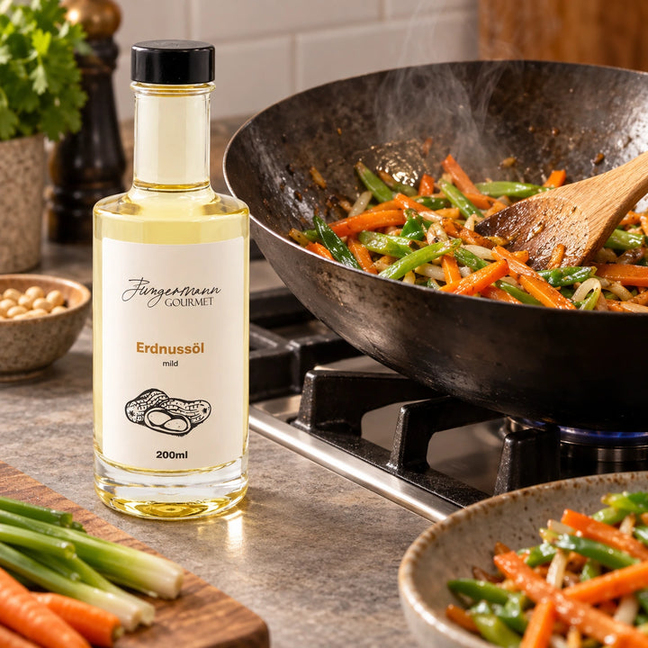 Gemüse wird im Wok zubereitet; daneben steht die 200-ml-Originalflasche Erdnussöl.