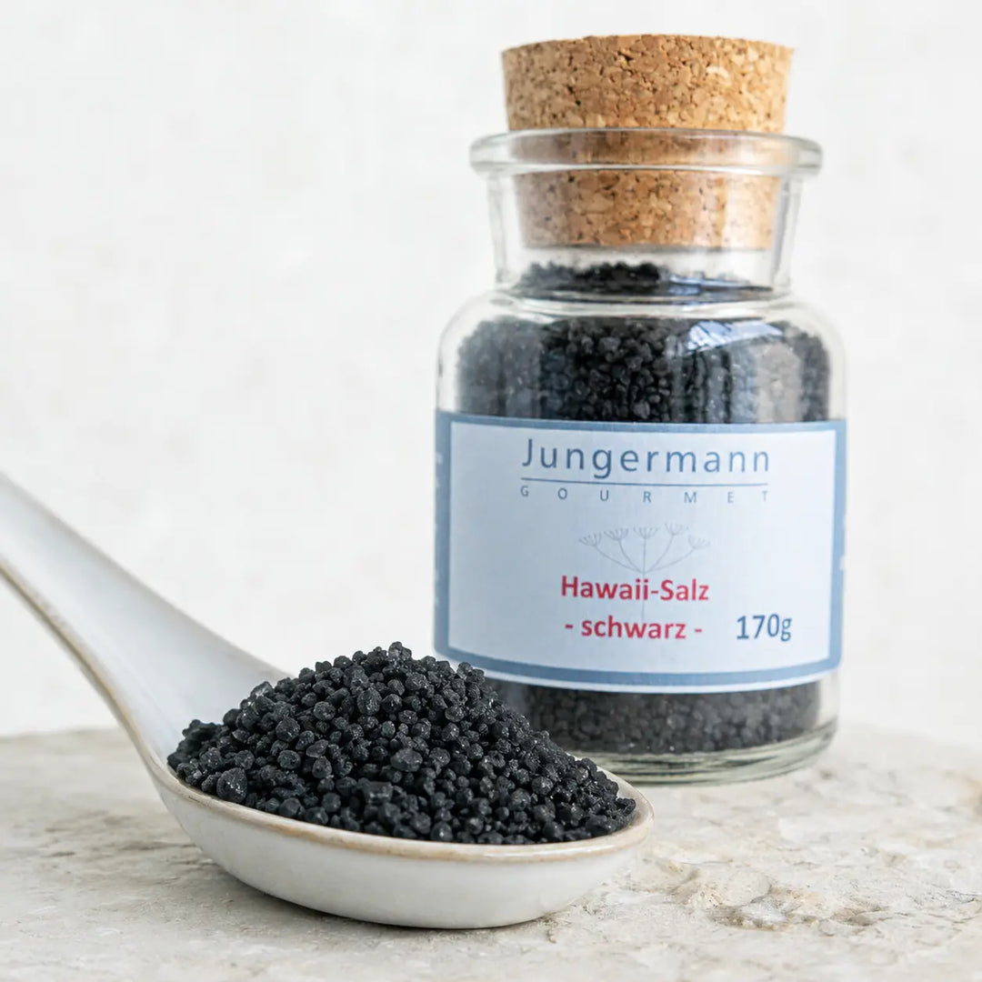 Grobe schwarze Black-Lava-Salzkristalle im Detail vor dem originalen Korkglas