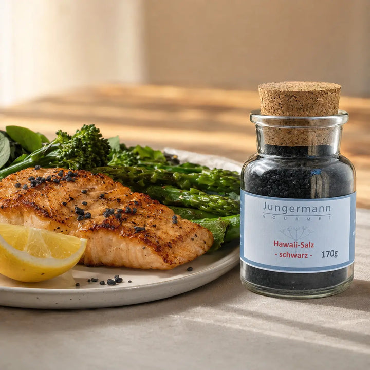 Gegrillter Lachs mit grünem Gemüse neben dem originalen Glas mit schwarzem Hawaii-Salz