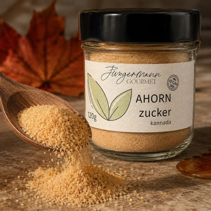 Feine Ahorn-Zucker-Kristalle auf einem Holzlöffel neben dem Produktglas