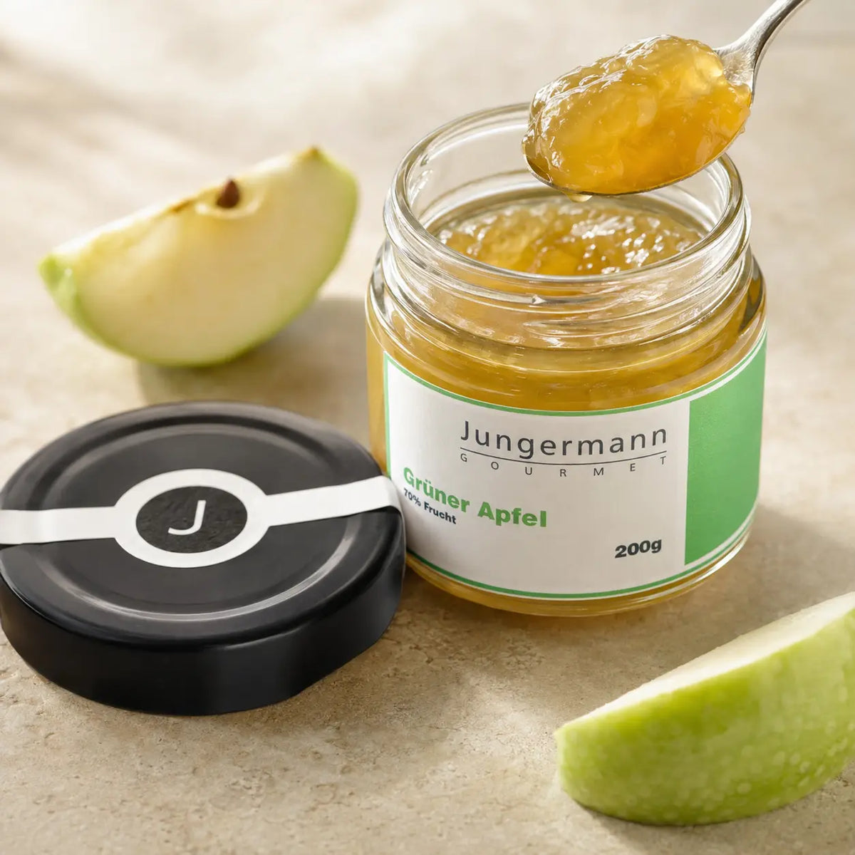 Geöffneter Apfel-Aufstrich von Jungermann Gourmet mit Löffel und Apfelstücken