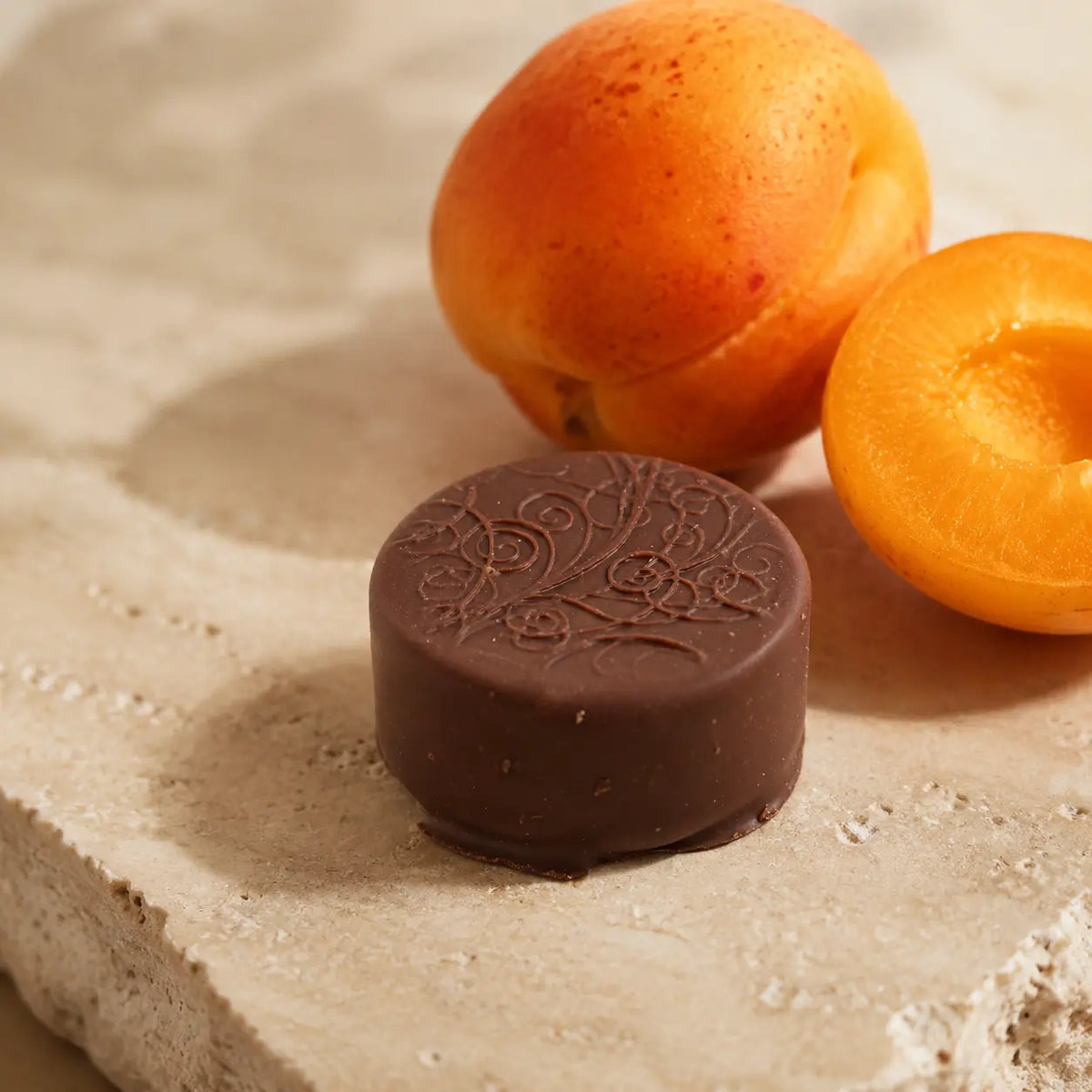Aprikosen Praline von Jungermann Gourmet mit feinem Schokoladenmuster und frischer Aprikose