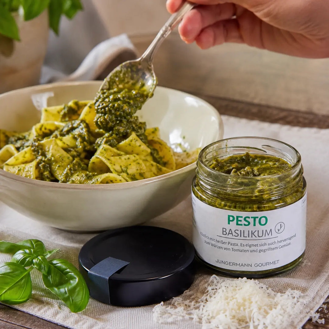 Basilikum-Pesto von Jungermann Gourmet wird unter warme Bandnudeln gehoben