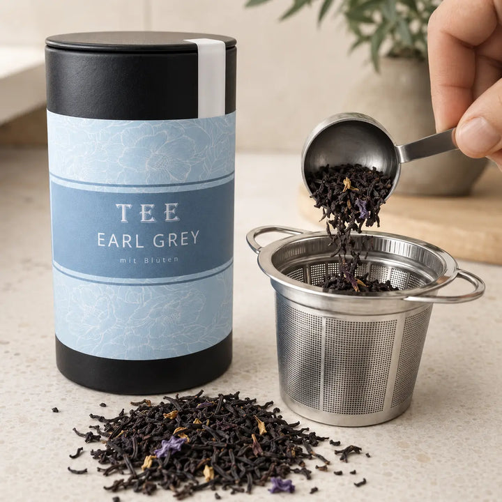 Earl Grey mit Blüten wird neben der Jungermann Gourmet Teedose dosiert