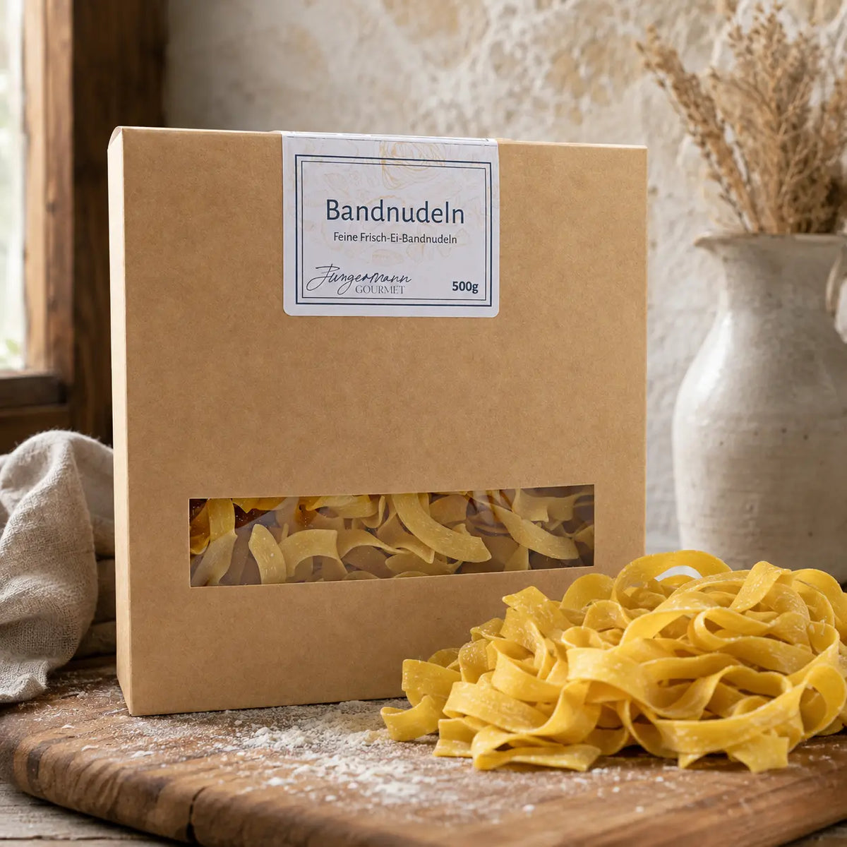 Goldene Frisch-Ei Bandnudeln mit Schachtel auf einem Holzbrett