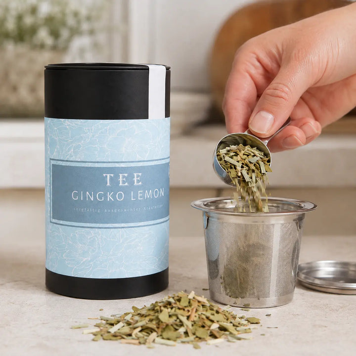Gingko Lemon Kräutertee wird neben der Jungermann Gourmet Teedose dosiert