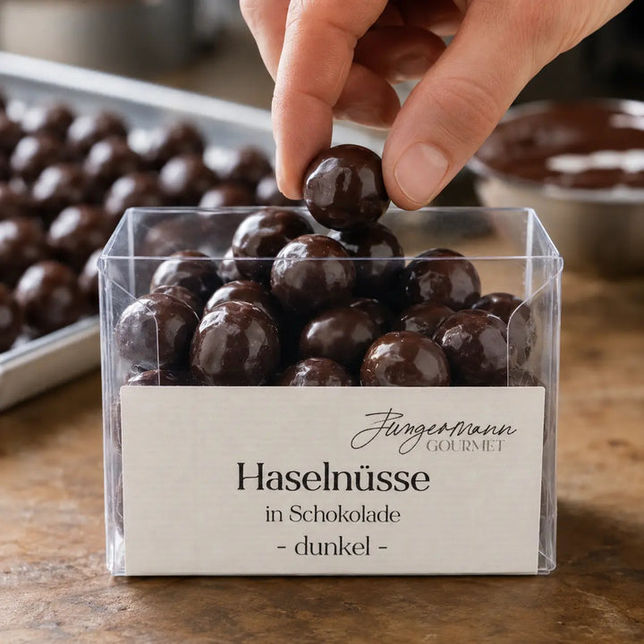 Haselnüsse in dunkler Schokolade beim Einfüllen in die Originalbox