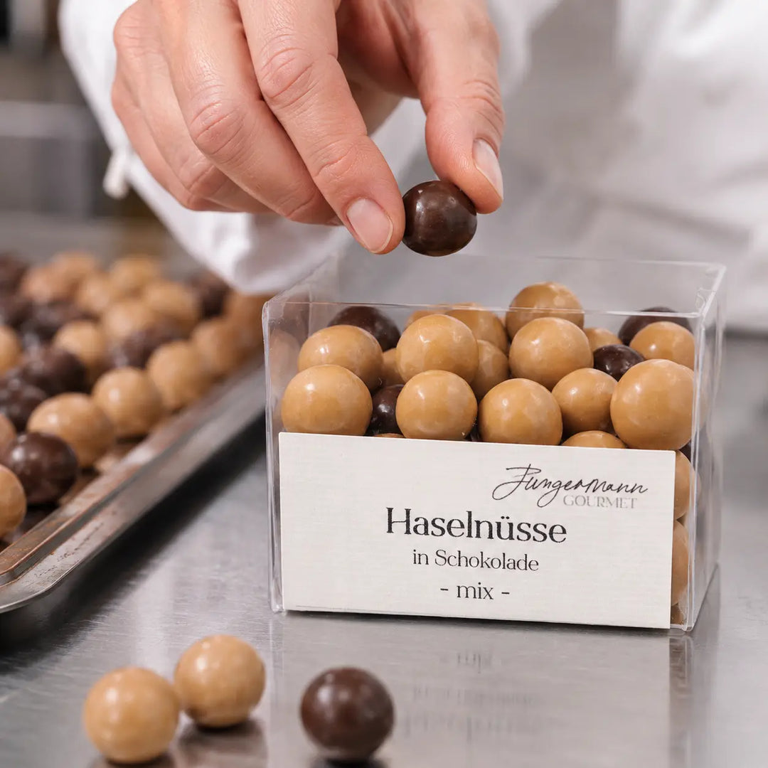 Haselnüsse in Schokolade Mix beim Einfüllen in die Originalbox