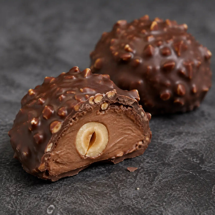 Haselnuss Praline im Anschnitt – Schokolade, Haselnussfüllung und Nussstückchen