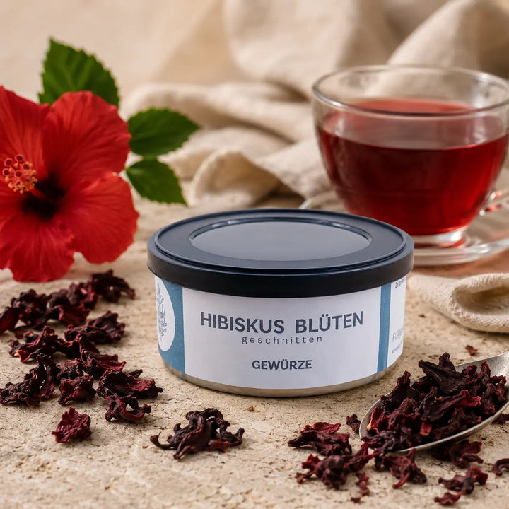 Hibiskusblüte geschnitten mit getrockneten Blütenstücken und Tee