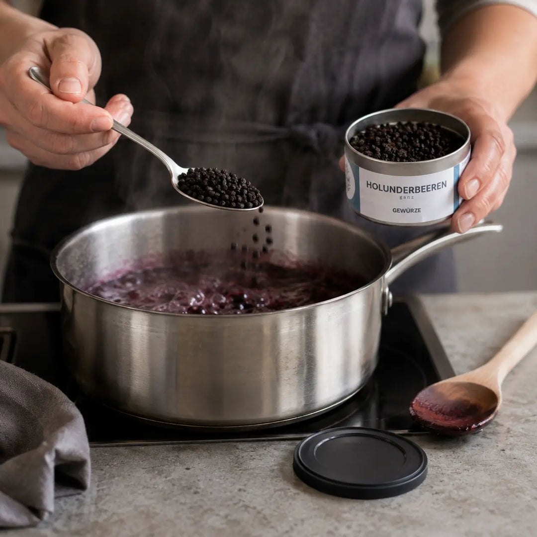 Getrocknete Holunderbeeren beim Einkochen einer Fruchtsauce
