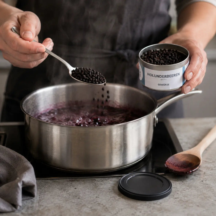 Getrocknete Holunderbeeren beim Einkochen einer Fruchtsauce
