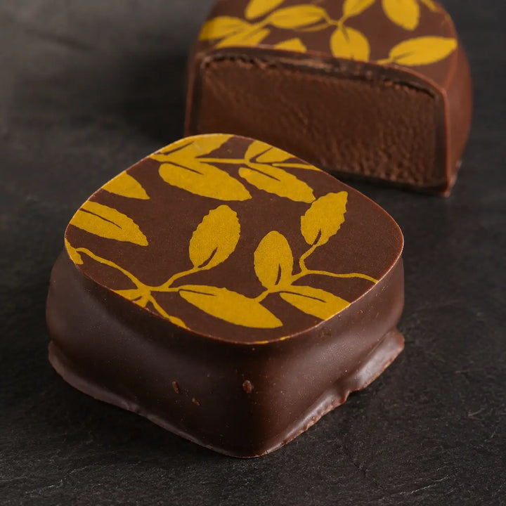 Jasmin-Tee Praline mit goldenem Blattmuster und Ganache im Detail