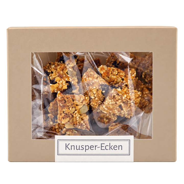 Knusper-Ecken von Jungermann Gourmet in der Gebäckschachtel mit Sichtfenster – freigestellte Frontalansicht.