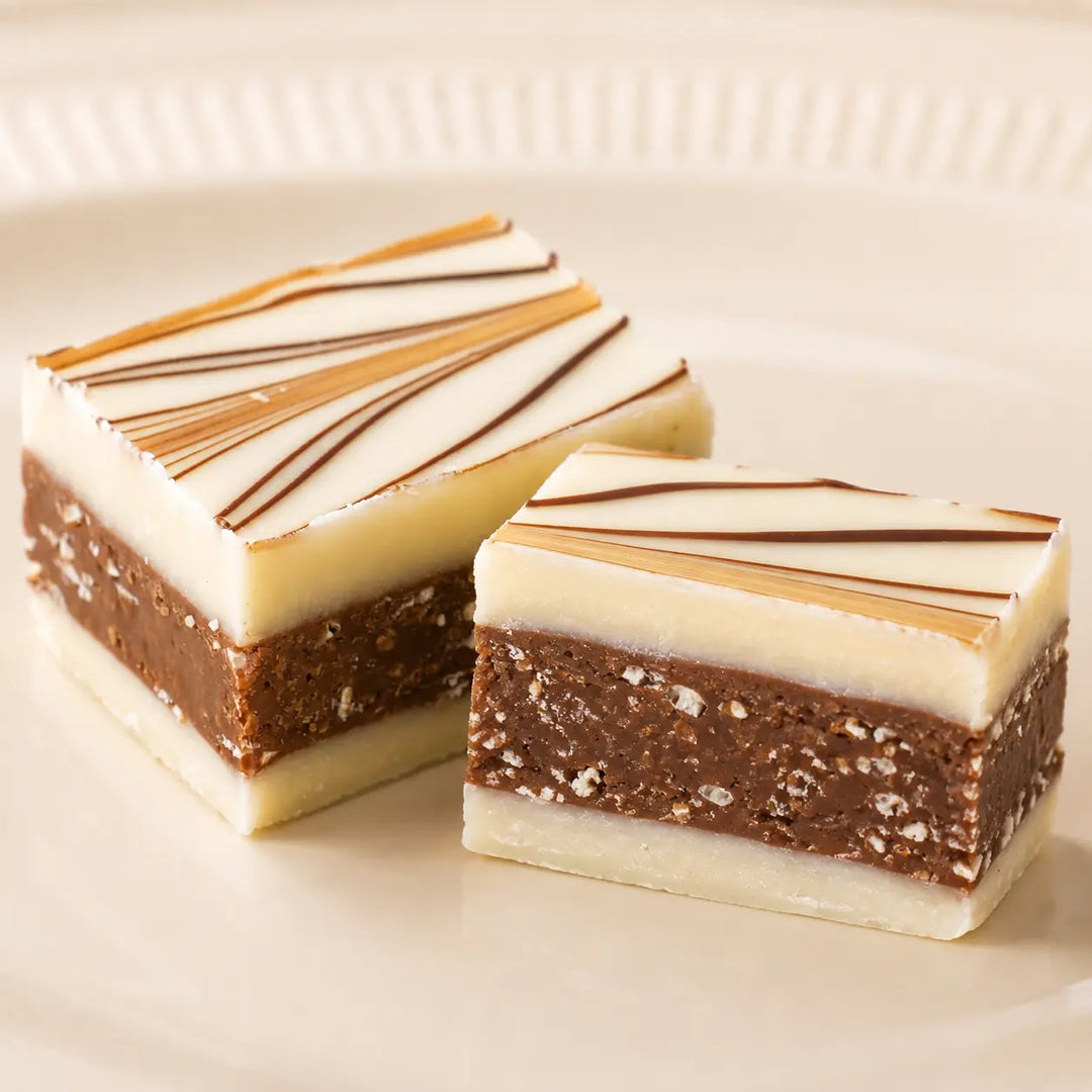 Weiße Knusper-Praline mit brauner knuspriger Cerealienfüllung im Detail