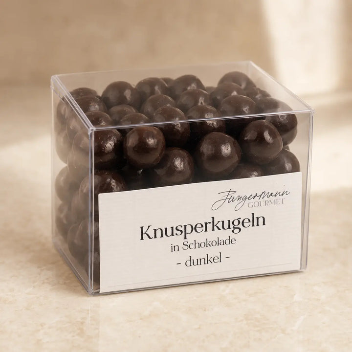Dunkle Knusperkugeln in Schokolade in der originalen transparenten Jungermann-Gourmet-Box