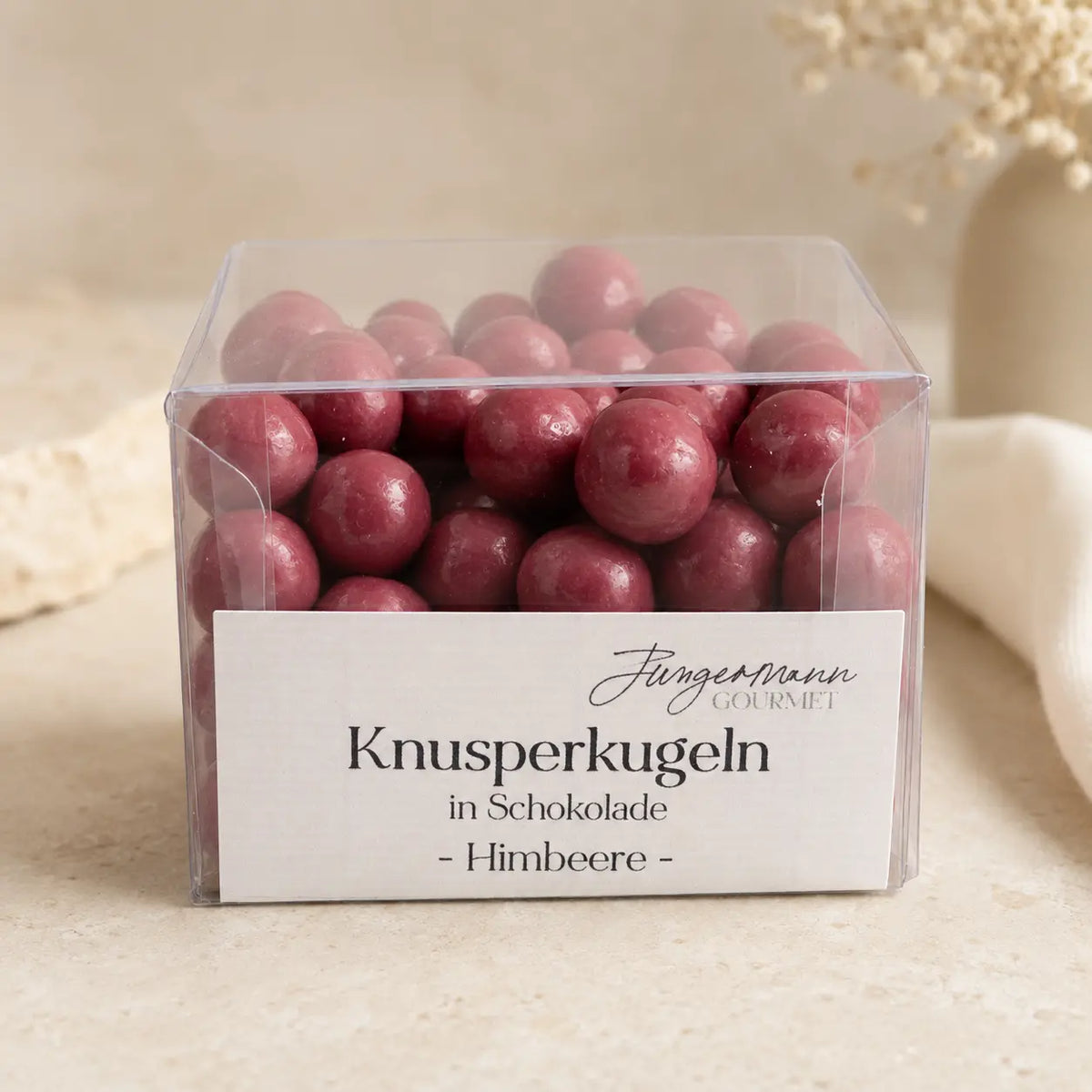 Himbeer-Knusperkugeln in Schokolade in der originalen transparenten Jungermann-Gourmet-Box