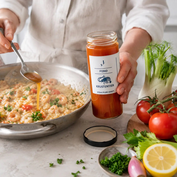 Krustentier-Fond beim Kochen eines Risottos mit Garnelen, Tomate, Fenchel und Petersilie