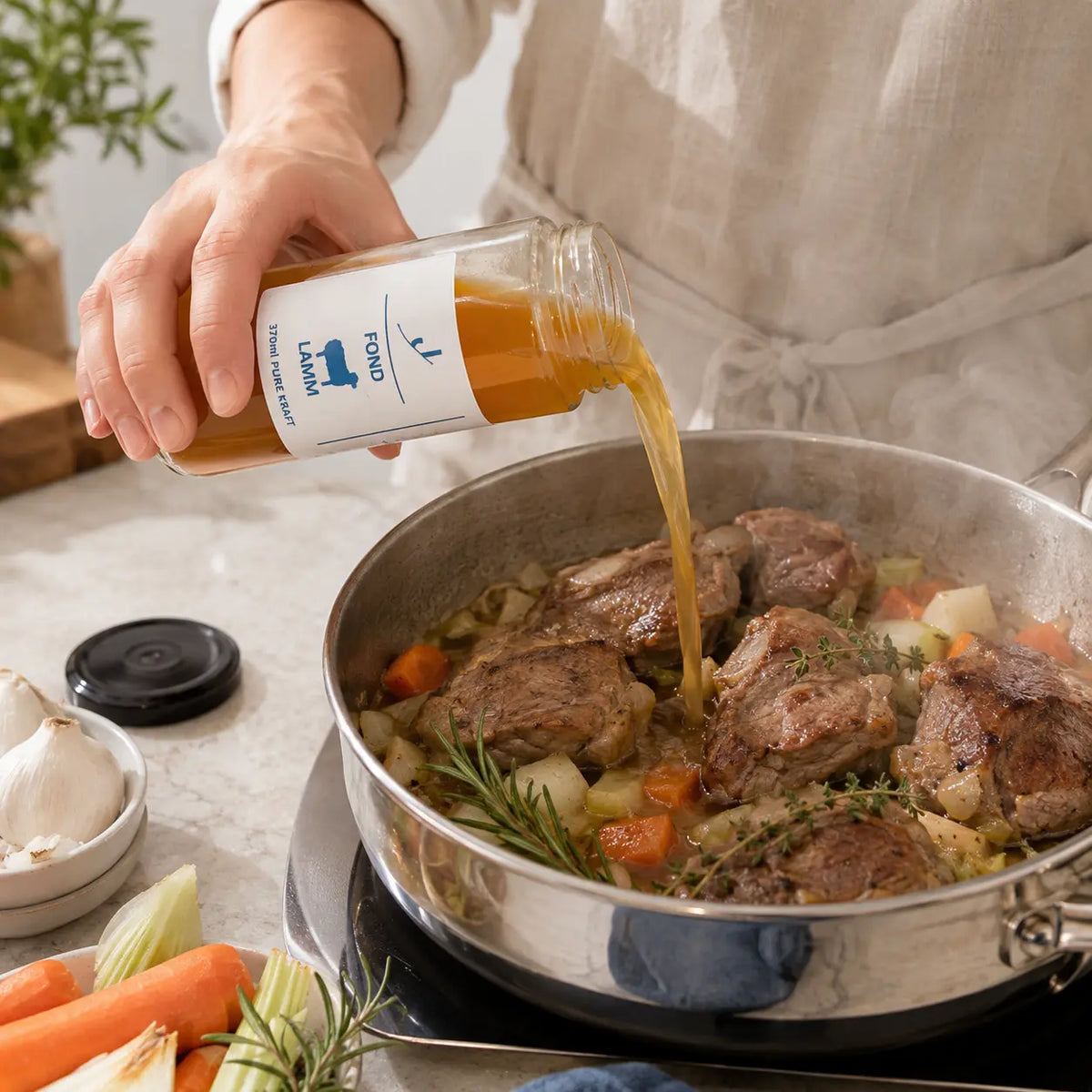 Lamm-Fond beim Angießen von Lamm mit Karotten, Sellerie, Knoblauch, Rosmarin und Thymian