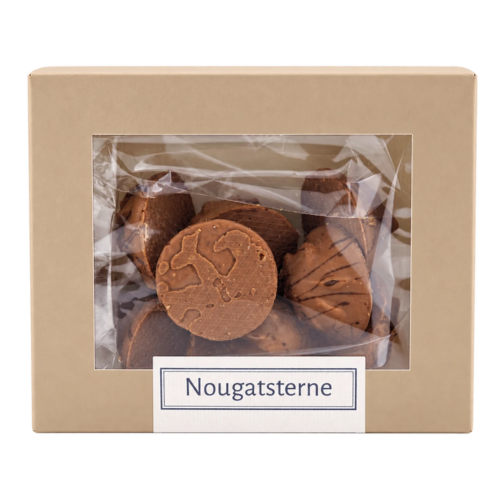 Nougatsterne von Jungermann Gourmet in der Gebäckschachtel mit Sichtfenster – freigestellte Frontalansicht.