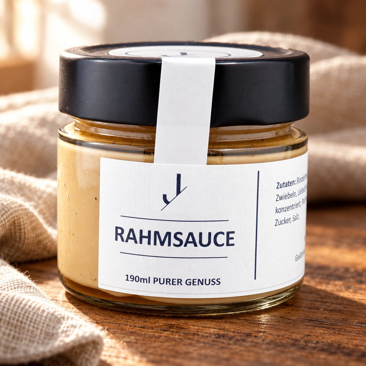 Das Originalglas Jungermann Gourmet Rahmsauce mit schwarzem Deckel auf einem Holztisch.