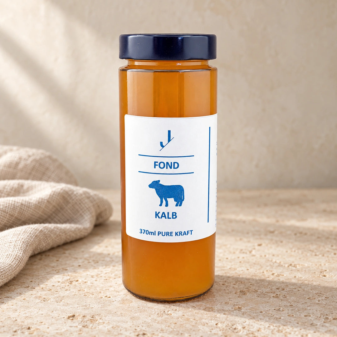 Kalb-Fond Knochenbrühe im originalgetreuen 370-ml-Glas auf hellem Naturstein neben einem Leinentuch.