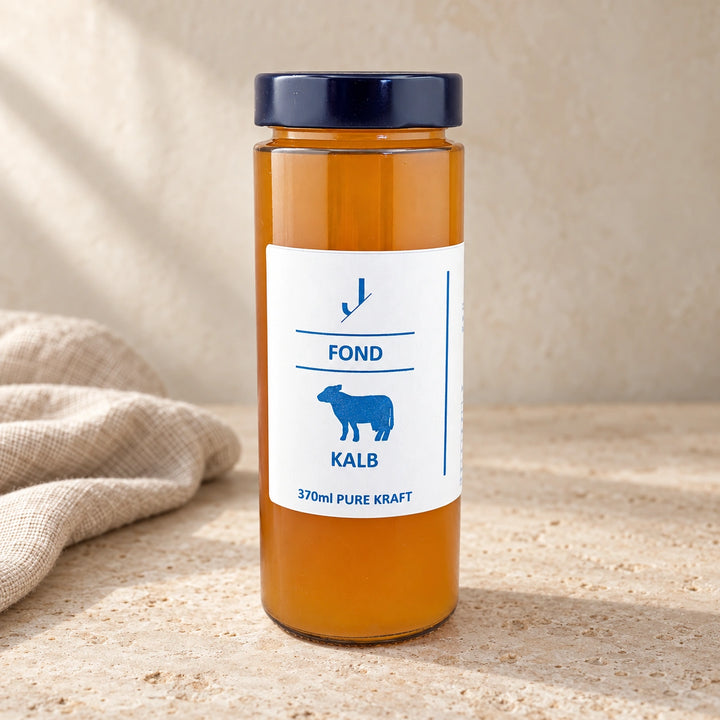 Kalb-Fond Knochenbrühe im originalgetreuen 370-ml-Glas auf hellem Naturstein neben einem Leinentuch.