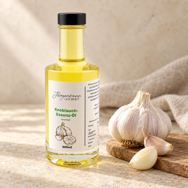 Knoblauch-Essenzöl in der 200-ml-Originalflasche neben einer Knoblauchknolle und einzelnen Zehen auf hellem Naturstein.
