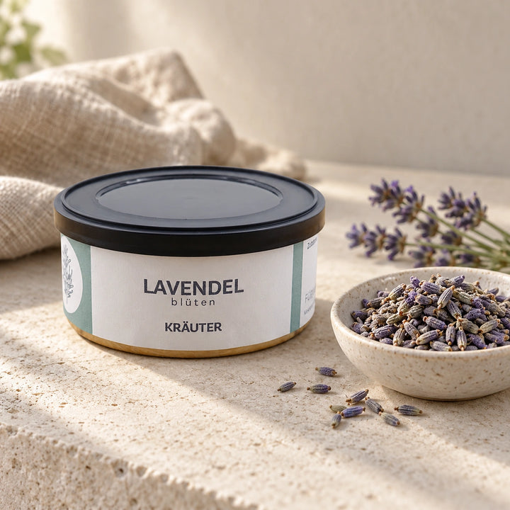 Lavendelblüten in der Originaldose neben getrockneten Blüten in einer Keramikschale und Lavendelzweigen.