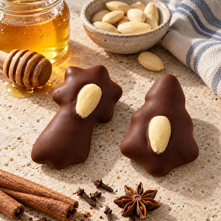 Lebkuchen von Jungermann Gourmet mit passenden Zutaten auf hellem Naturstein – Sternschnuppe und Tannenbaum mit Schokolade und Mandel.