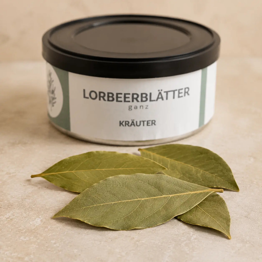 Ganze getrocknete Lorbeerblätter im Detail vor der Kräuterdose