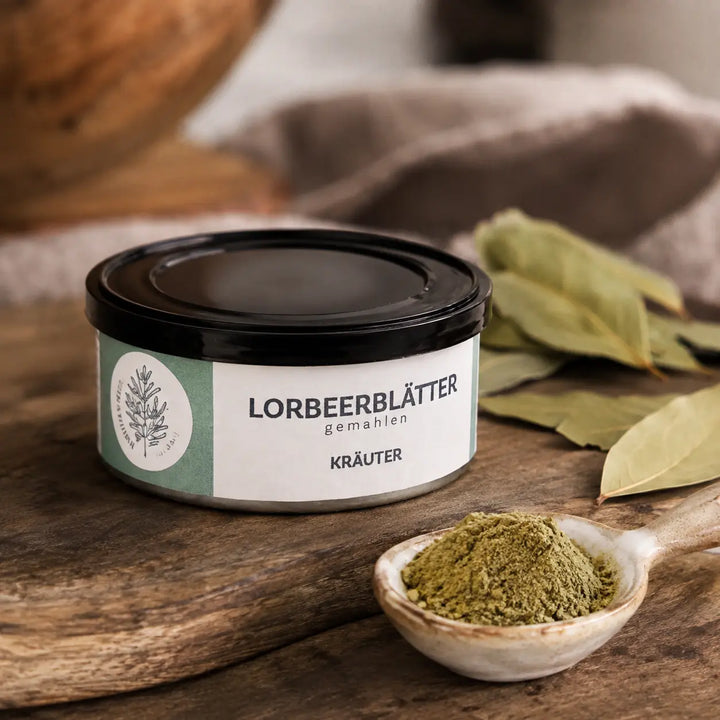 Gemahlene Lorbeerblätter im Detail mit ganzen Lorbeerblättern als Zutat