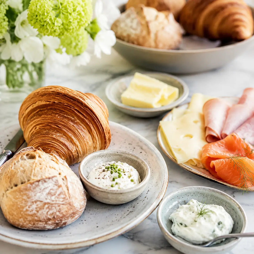 Croissants und Brötchen mit Käse, Schinken, Räucherlachs, Butter und Frischkäse