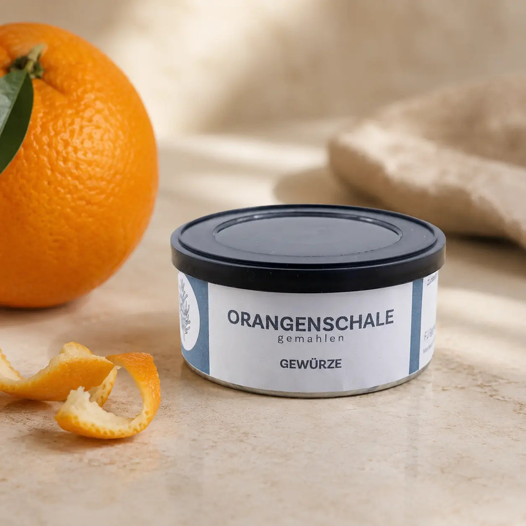 Gemahlene Orangenschale in originaler Gewürzdose als hochwertiger Packshot mit Orange