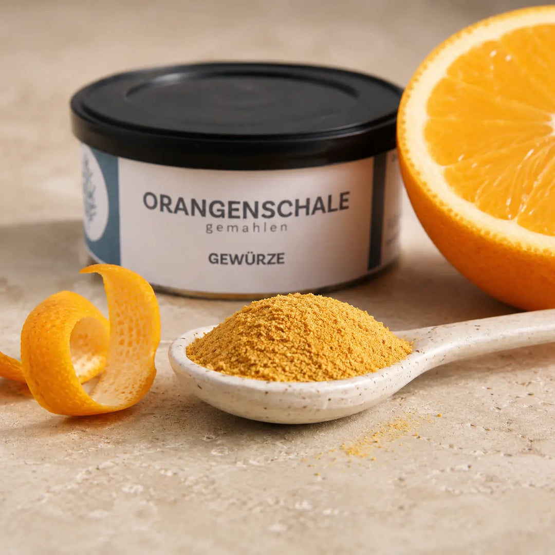 Fein gemahlene Orangenschale auf Keramiklöffel mit Orangenschale und frischer Orange
