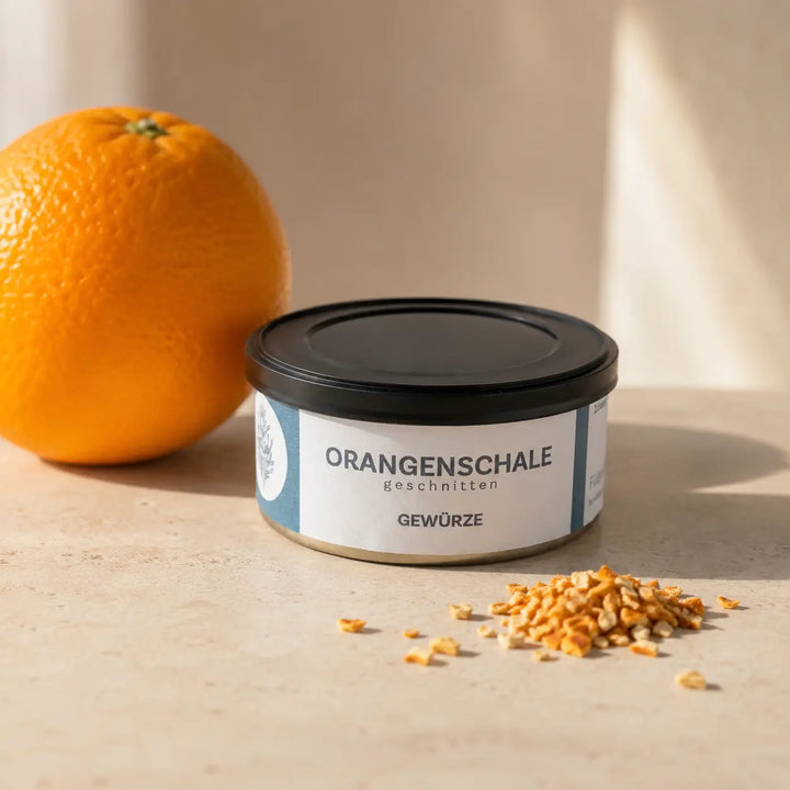 Geschnittene Orangenschale in originaler Gewürzdose als hochwertiger Packshot mit Orange