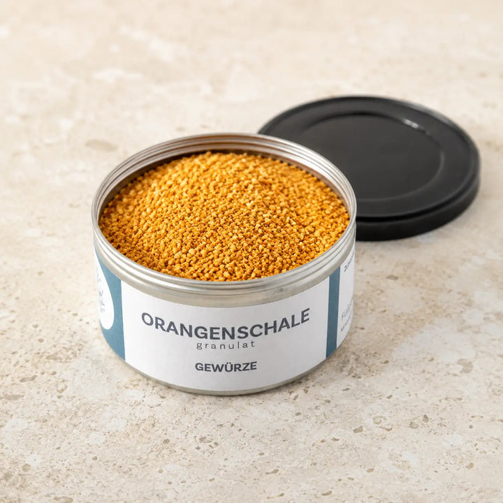 Geöffnete originale Gewürzdose mit feinem Orangenschalen-Granulat und schwarzem Deckel