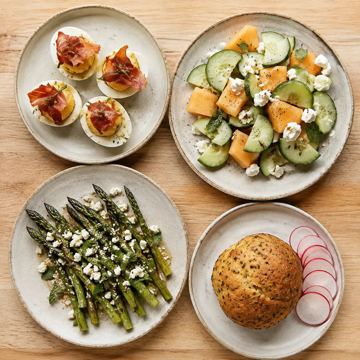 Gefüllte Eier, Gurken-Feta-Melonensalat, Spargelsalat und Kräuterbrot mit Radieschen