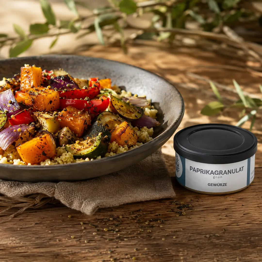 Geröstetes Gemüse mit Couscous neben der originalen Dose mit grünem Paprikagranulat