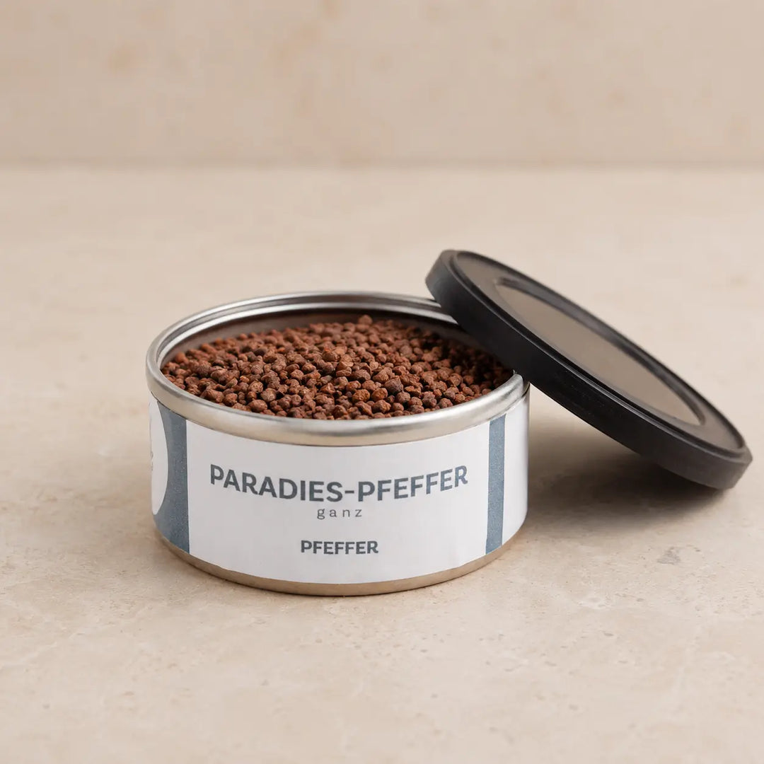 Geöffnete Originaldose mit kleinen rotbraunen Paradieskörnern und schwarzem Deckel