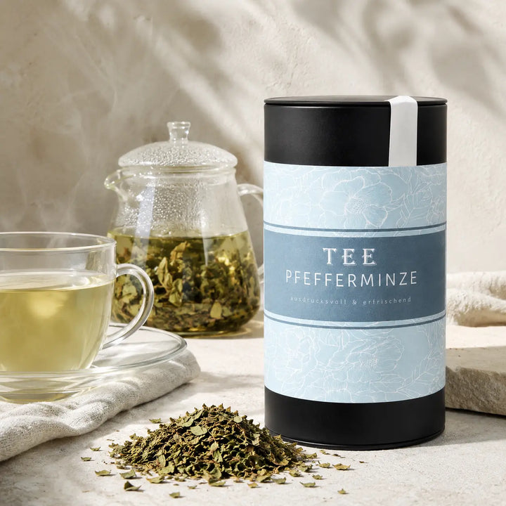 Pfefferminze Tee mit Glastasse, Teekanne und getrockneten Minzblättern