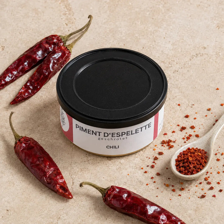 Originale Dose Piment d’Espelette mit getrockneten roten Chilis und groben Chiliflocken