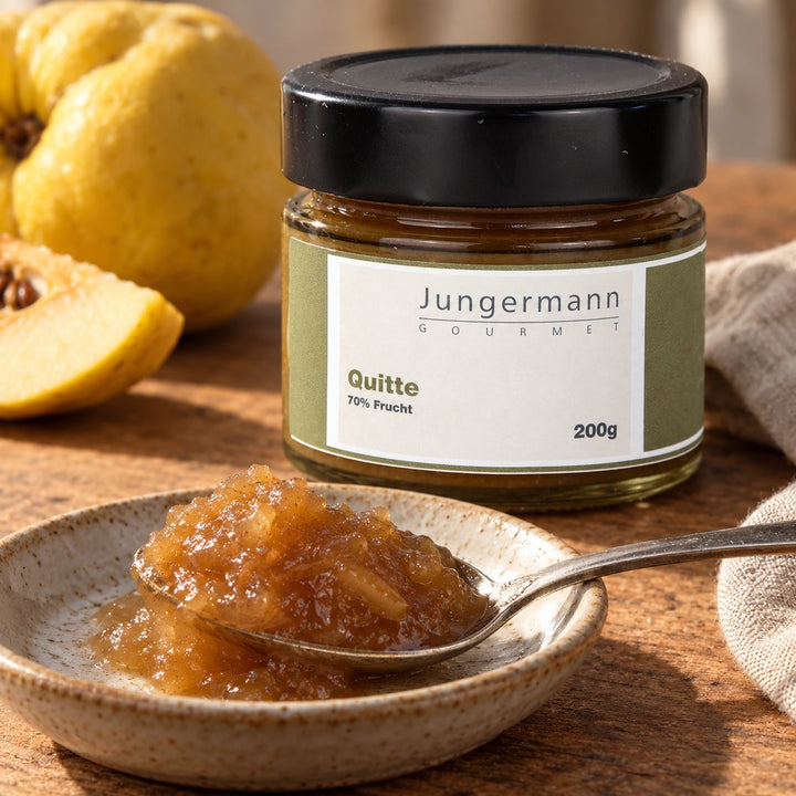 Nahaufnahme von goldbraunem Quittenaufstrich auf einem Löffel vor dem Originalglas.