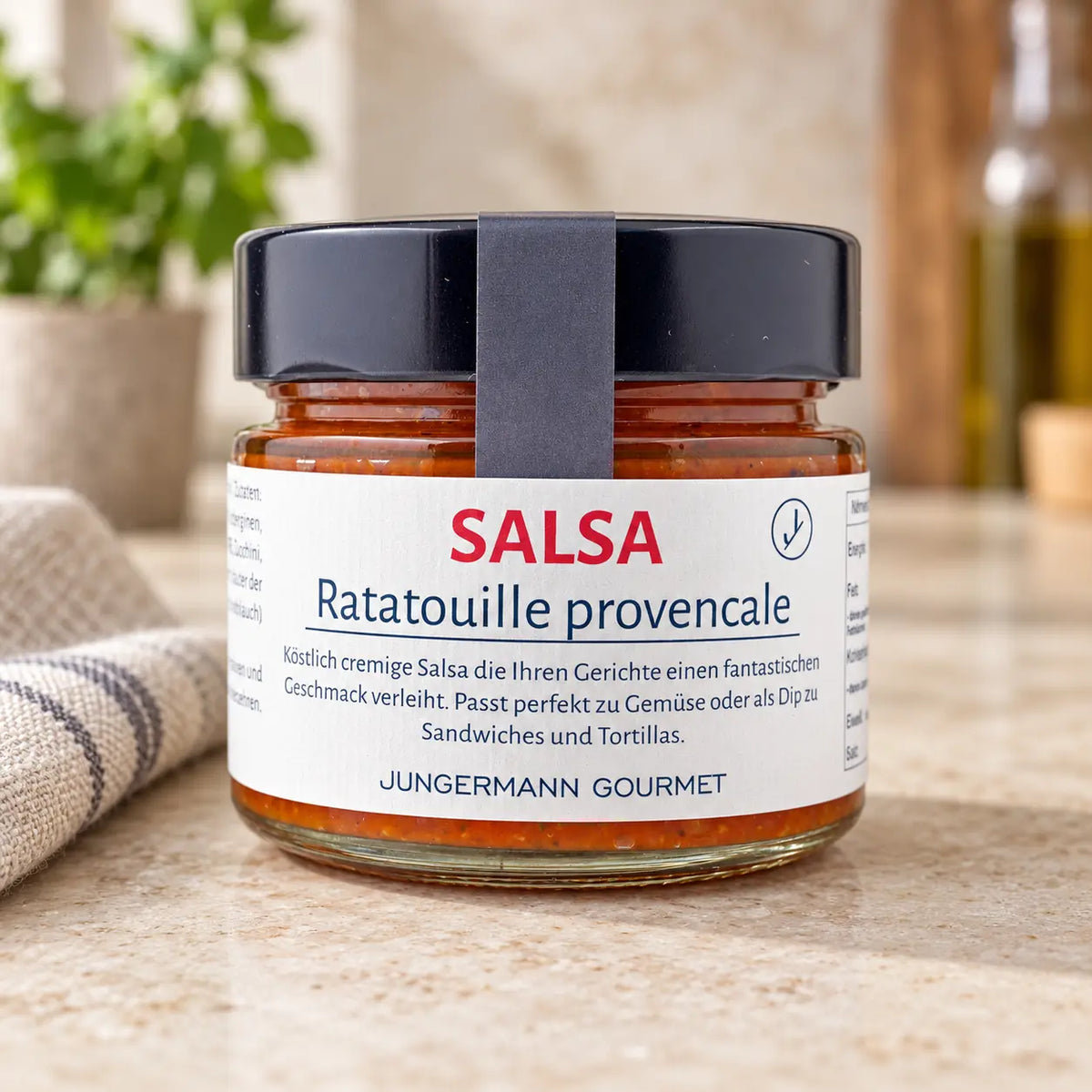 Ratatouille Salsa von Jungermann Gourmet im Originalglas mit schwarzem Deckel auf einer hellen Küchenarbeitsfläche.
