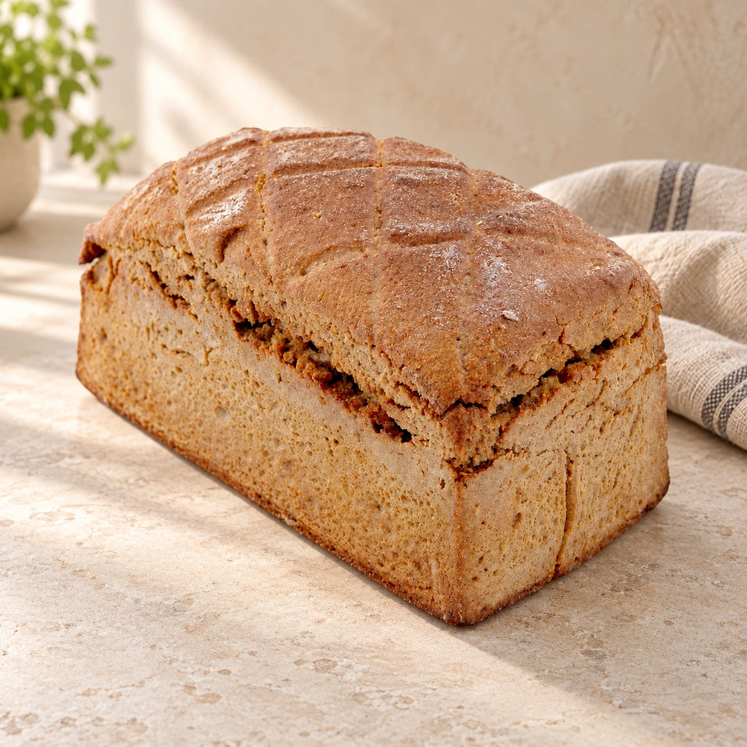 Roggenbrot 600 g von Jungermann Gourmet mit brauner Kruste und Einschnitten auf einer hellen Natursteinfläche.